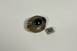A 19th century banded agate and enamel mourning brooch, of shaped oval form, centred by an oval-