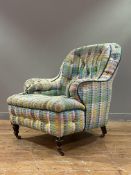 A Victorian easy chair of country house proportions, the swept back, arms, and seat upholstered in