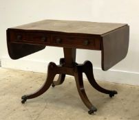 A Regency period mahogany sofa table, the top with cross band and drop leaf to each end above two