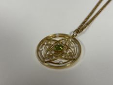 A large Edwardian 15ct gold, peridot and seed pearl pendant, circular, centred by an oval-cut