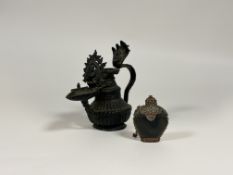 A bronze oil lamp, late 19th century, probably Nepal or Tibet, with gadrooned body, the handle and