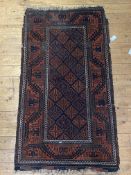 An Antique hand knotted Baluchi rug, the central panel with repeating lozenge design and having