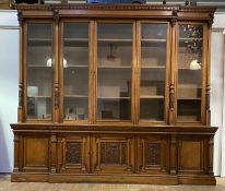 A large Victorian oak breakfront bookcase, the dentil cornice above a frieze with lion mask