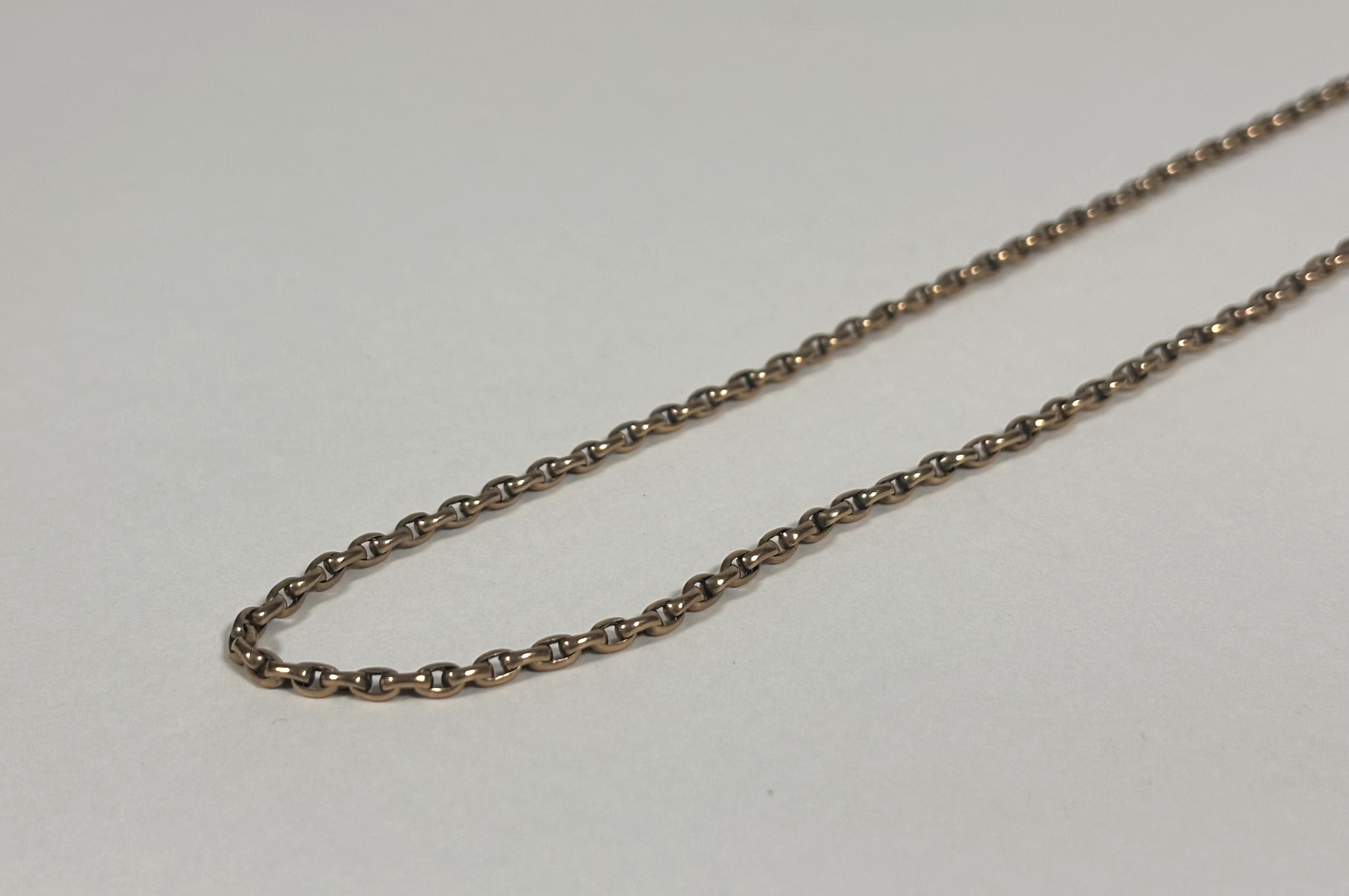 A yellow metal belcher link guard chain, unmarked, the lobster clasp indistinctly stamped. Length
