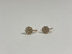 A pair of small late 19th/early 20th century diamond flowerhead earrings, each set to the centre