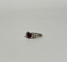 A ruby and diamond cluster ring, the oval-cut ruby weighing c. 1ct, (ruby chipped and with