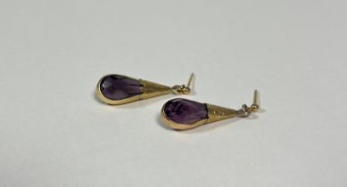 A pair of late 19th century yellow metal-mounted amethyst drop earrings, the pear-cut faceted