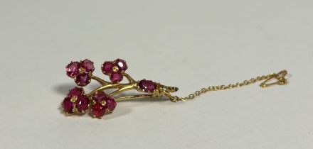 A ruby-set brooch, formed as a flowering branch, set with four three-stone flowerheads, claw-set,