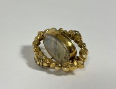 A late Victorian yellow metal swivel brooch, the central oval glazed double-sided locket enclosing