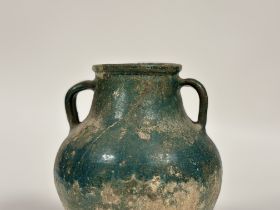An Islamic, Kashan, glazed pottery twin-handled jar, probably 12th/13th century, with iridescent