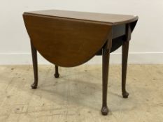 A George III mahogany drop leaf table, with oval top raised on turned swing leg supports with pad