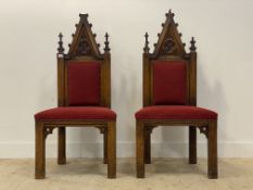 A pair of Gothic revival oak hall chairs, late 19th century, the arched crest rail carved in low