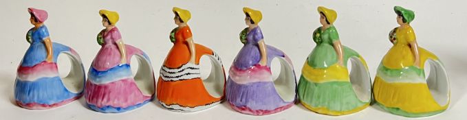 A set of six variously decorated Carlton Ware napkin holders modelled as ladies (all marked verso,