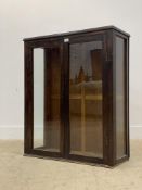 An early 20th century stained oak glazed bookcase cabinet, with two doors enclosing two shelves.