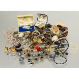 A collection of costume jewelry to include a carved bead necklace, gilt metal pendants and chains,
