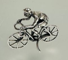 A silver miniature figure on a racing bike in jersey, shorts and cap no signs of damage or hard