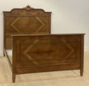 A French walnut and oak panel bed frame, circa 1900, the headboard carved with linen swags centred
