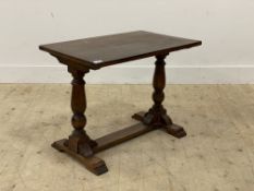 An early 20th century oak stretcher table, the oval top raised on panel end supports. H58cm,