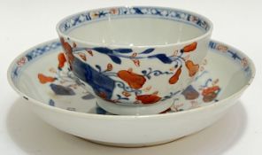 An eighteenth century Chinese export ware tea bowl and saucer decorated in iron red and cobalt