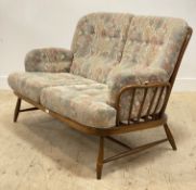 Ercol, a vintage stained beech framed two seat sofa, with hoop and spindle back above squab