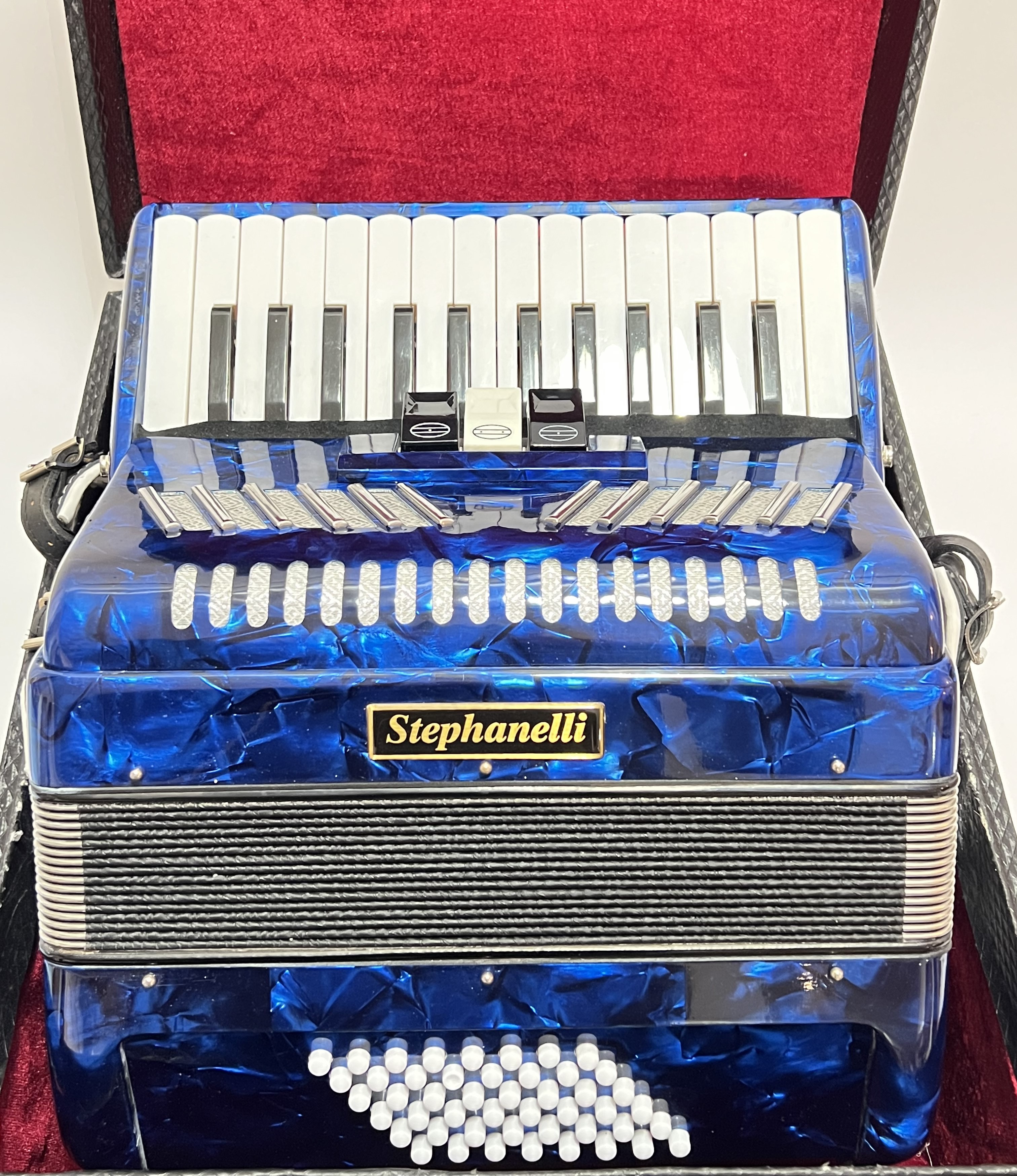 A blue Stephanelli 48 bass accordion accompanied by a fitted hard case