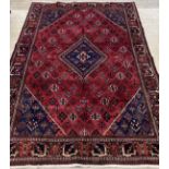 A Persian mahal joshagan carpet, the busy red field with floral motifs, lozenge medallion and