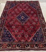 A Persian mahal joshagan carpet, the busy red field with floral motifs, lozenge medallion and