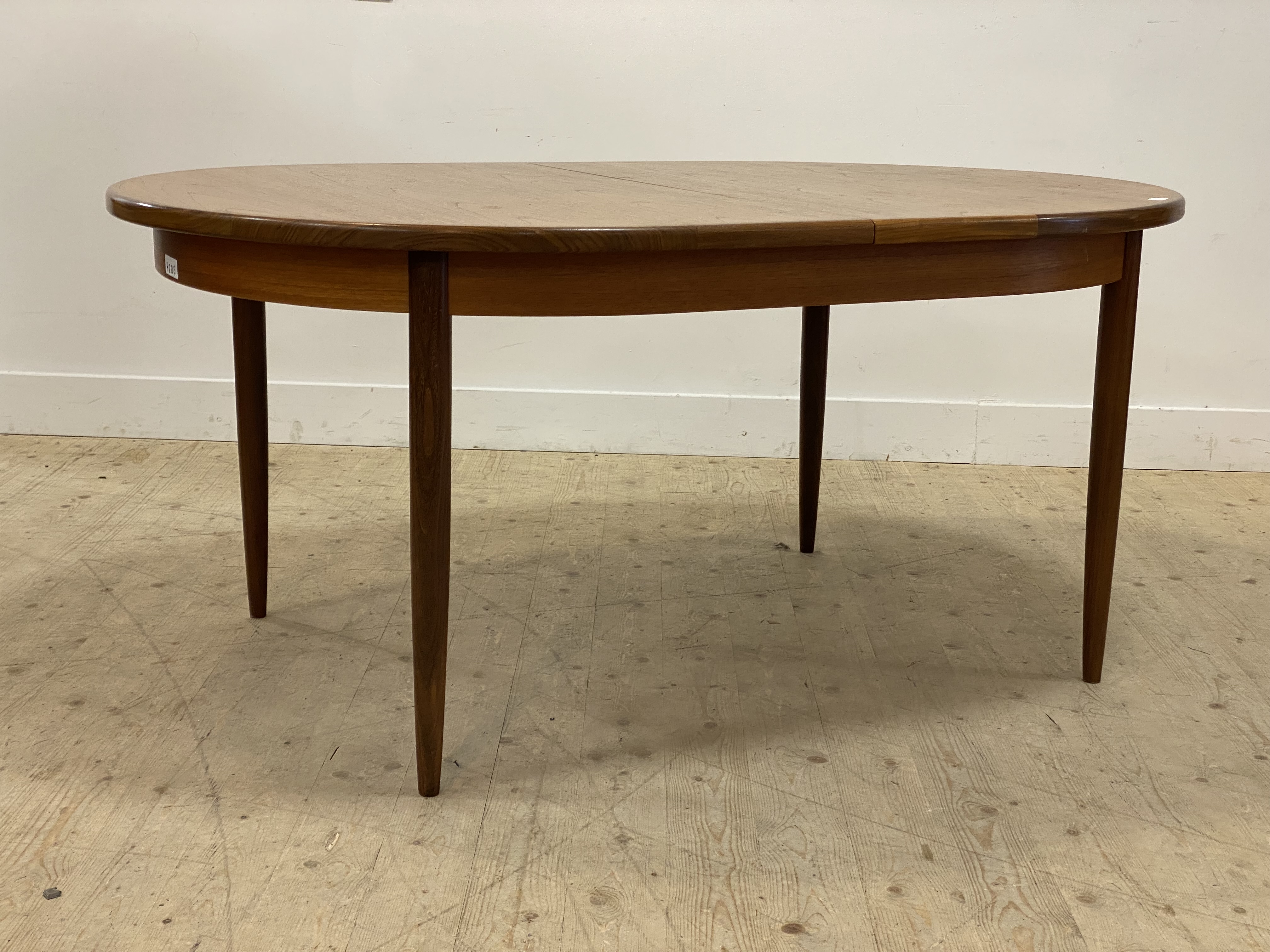 G-Plan, a mid century teak extending dining table, the oval top opening to an extra leaf, raised