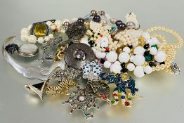 A collection of costume jewellery to include a paste set elephant brooch, tiger brooch, vintage