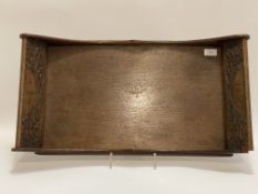 An early 20th century oak twin handled tray of rectangular outline, carved in low relief with