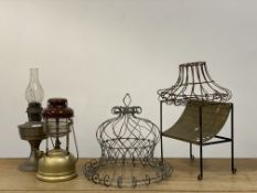 A group lot, comprising two wirework planters, a tilley lamp and an oil lamp, a brass and wrought