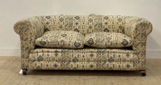 A late Victorian chesterfield two seat sofa, with squab cushion, and upholstered in geometric