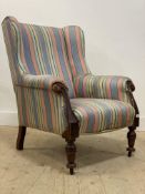 A mid 19th century wingback drawing room armchair, upholstered in stripped cotton, and with scroll