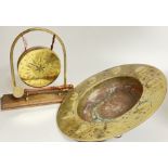 A brass dinner gong and striker (h- 26cm), together with a beaten brass dish, probably nineteenth