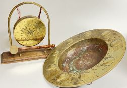 A brass dinner gong and striker (h- 26cm), together with a beaten brass dish, probably nineteenth