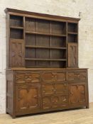 An oak dresser of 17th century design, the plate rack with five open shelves and two geometric