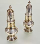 A pair of Victorian Birmingham silver pepperettes of Georgian style with urn finials and pierced and
