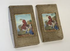 A pair of frosted etched glass bookends in the style of a book with a picture panel to centre of a