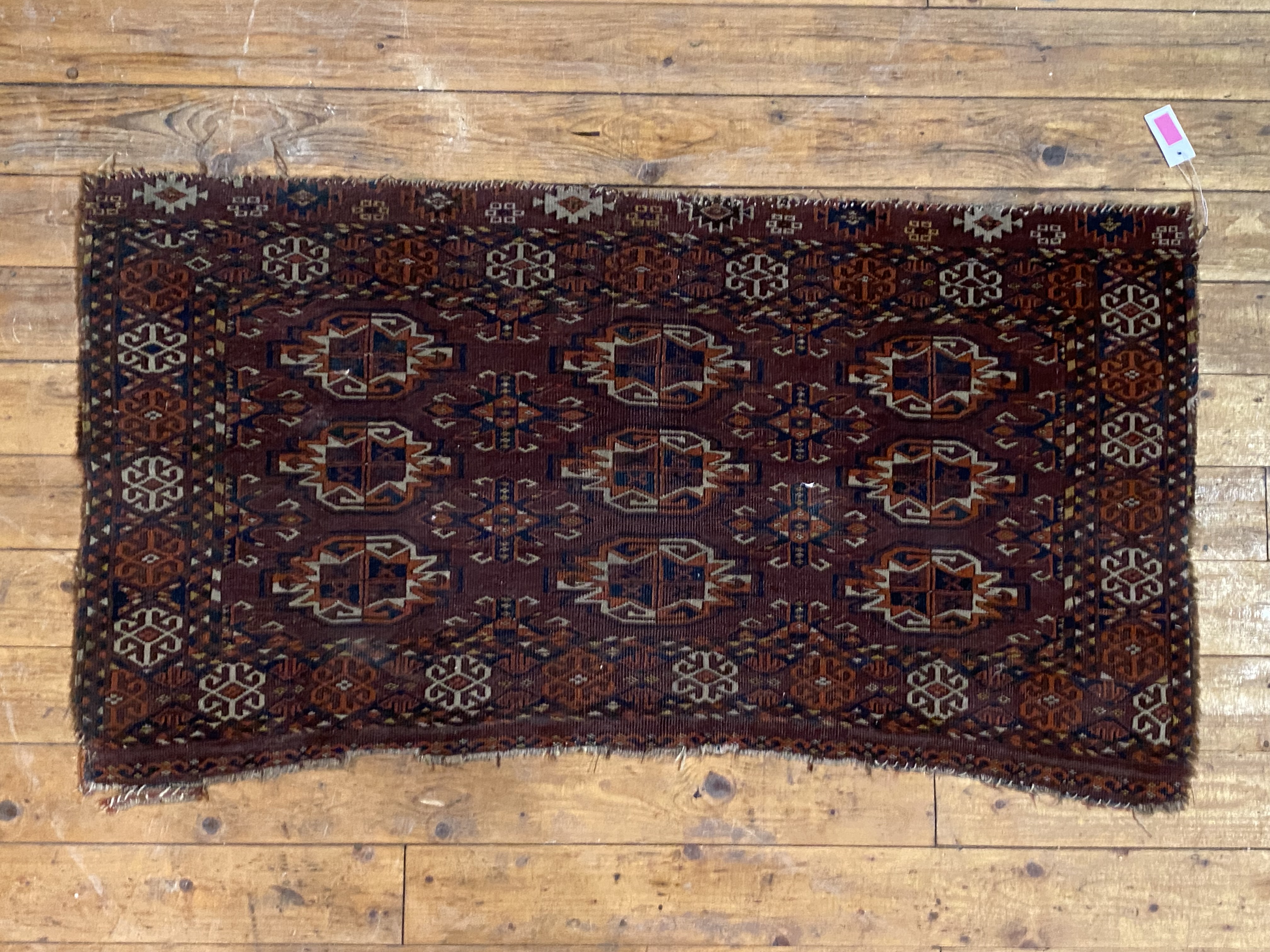 A large Turkmen Tekke bag face rug or wall hanging, late 19th century, the field, of dark red,