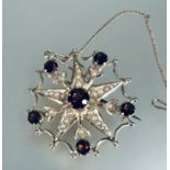 A Edwardian 9ct gold star garnet and seed pearl set brooch with central claw set garnet 0.5ct within