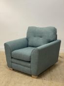A contemporary lounge chair, upholstered in blue linen and raised on block supports H73cm, 94cm x