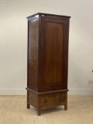 An early 20th century mahogany hall cupboard, the single panelled door enclosing an interior