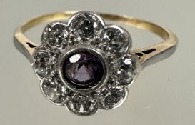 A Edwardian yellow and white metal cluster ring, the central circular faceted amethyst in rub over