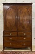 An early 19th century mahogany linen press, the arcaded frieze above two oval panelled doors