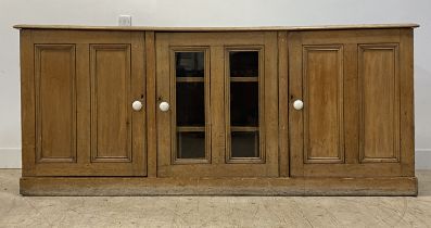 A Victorian pine sideboard / dresser base, fitted with a glazed cupboard door to centre, and flanked