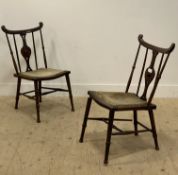 A pair of Edwardian Arts and Crafts chairs, with shaped crest above spindle and splat back,