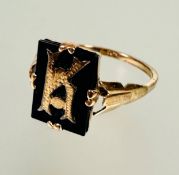 A 9ct gold cushion cut onyx panel signet style ring inset with letter K in four claw setting no