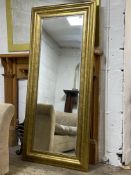 A large traditional gilt composition framed wall hanging mirror with bevelled plate. H180cm x 81cm.