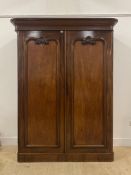 A Victorian mahogany wardrobe the projecting cornice above two scroll and shell carved panelled