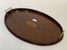 An Edwardian mahogany drinks tray of oval outline, centred by a boxwood conch shell inlay enclosed
